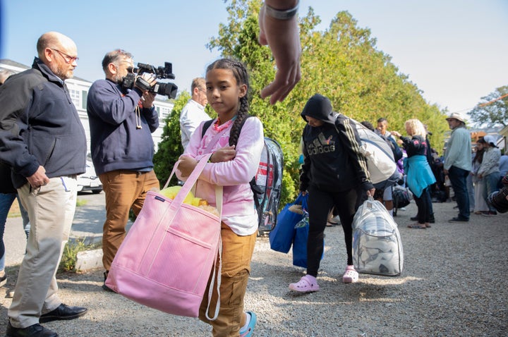 An underage migrant (center) is loaded onto a bus to be transported to Martha's Vineyard with dozens of other undocumented immigrants on Friday, Sept. 16.