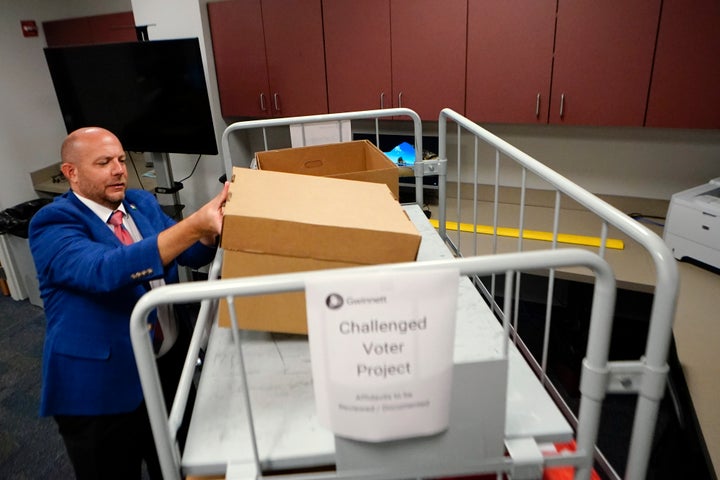 Gwinnett County elections supervisor Zach Manifold looks over boxes of voter challenges on Thursday, Sept. 15, 2022, in Lawrenceville, Ga. Manifold estimated his office has a month to log and research the challenges, before mail ballots go out for the November elections. âIt is a tight window to get everything done,â he said. (AP Photo/John Bazemore)