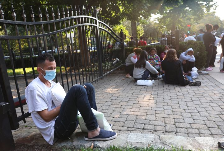 Migrants from Central and South America wait near the residence of Vice President Kamala Harris in Washington after being dropped off there on Sept. 15.