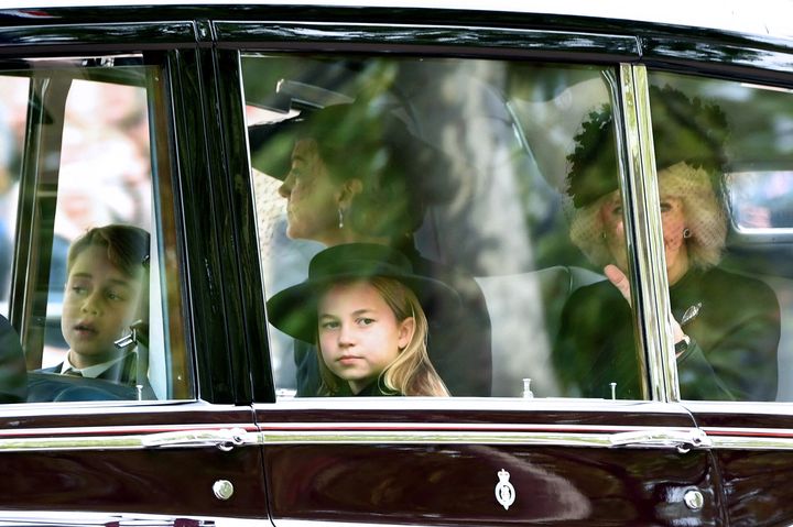 Prince George, Princess Charlotte, the Princess of Wales and Camilla, Queen consort, are seen on The Mall ahead of the state funeral. 