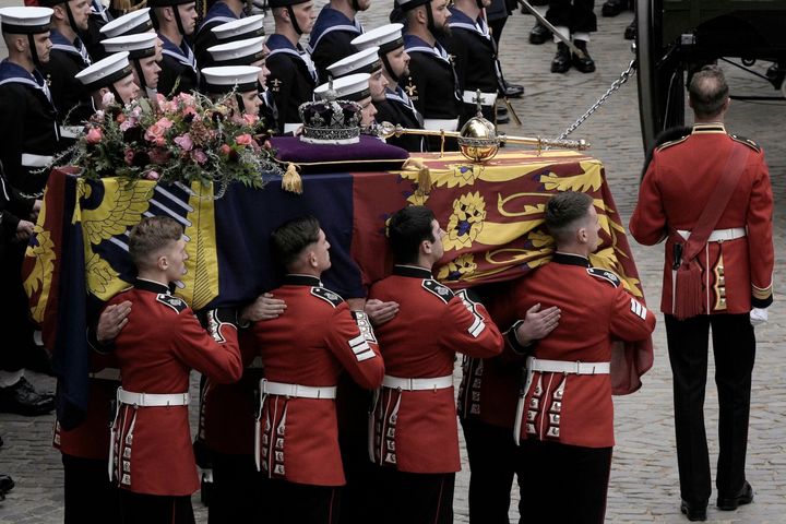 Queen Elizabeth's coffin, draped in the Royal Standard, is placed onto the State Gun Carriage of the Royal Navy.