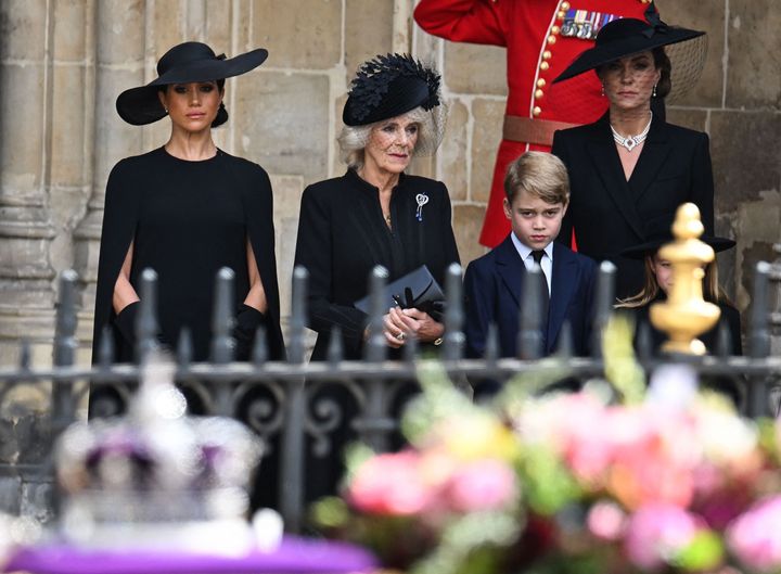 The Duchess of Sussex, the Queen Consort, Prince George of Wales and Catherine Princess of Wales look on at the coffin as they leave Westminster Abbey.