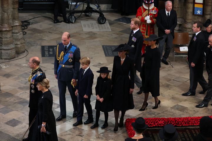 William, George, Charlotte and Kate walk in front of the Duke and Duchess of Sussex at the state funeral and burial of Queen Elizabeth. 
