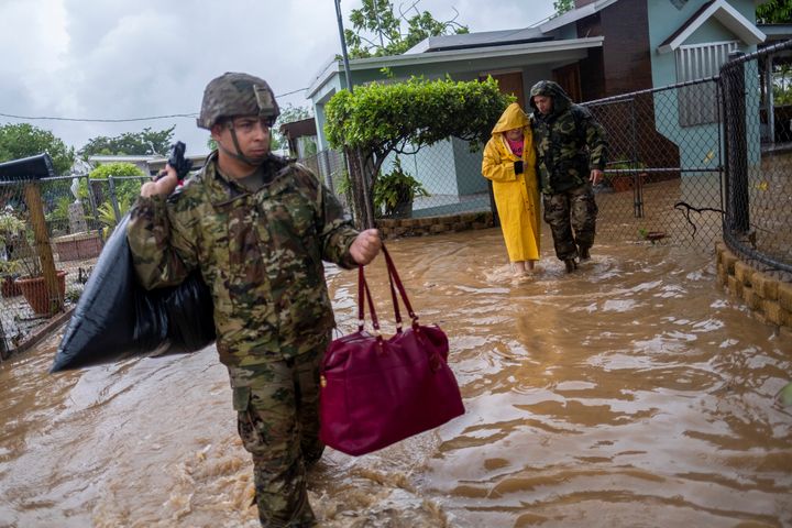 Members of the Puerto Rico National Guard rescue a woman stranded in her house in the aftermath of Hurricane Fiona in Salinas on Monday.