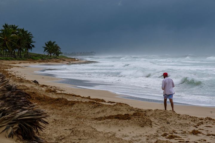 A man walks on the beach next to waves kicked up by Hurricane Fiona in Punta Cana, Dominican Republic, on Sept. 19, 2022.