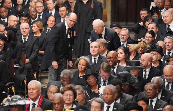 Joe Biden takes his seat several minutes late at Westminster Abbey. 