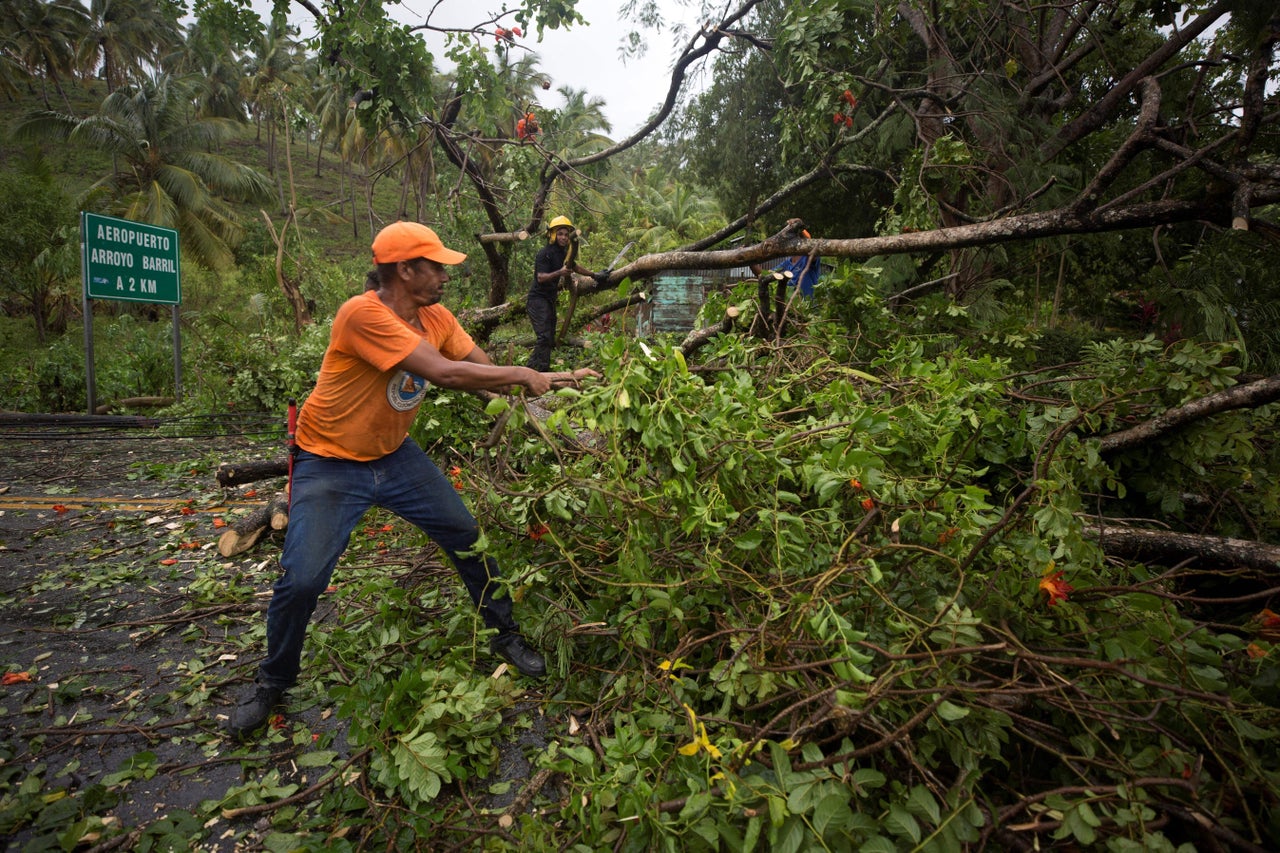 Civil protection personnel and firefighters work to clear fallen trees on a highway connecting the provinces of Maria, Trinidad, Sanchez and Samana in the Dominican Republic in the aftermath of Hurricane Fiona on Monday.