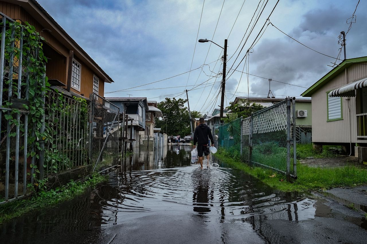 A man walks down a flooded street in the Juana Matos neighborhood of Catano, Puerto Rico, on Monday.