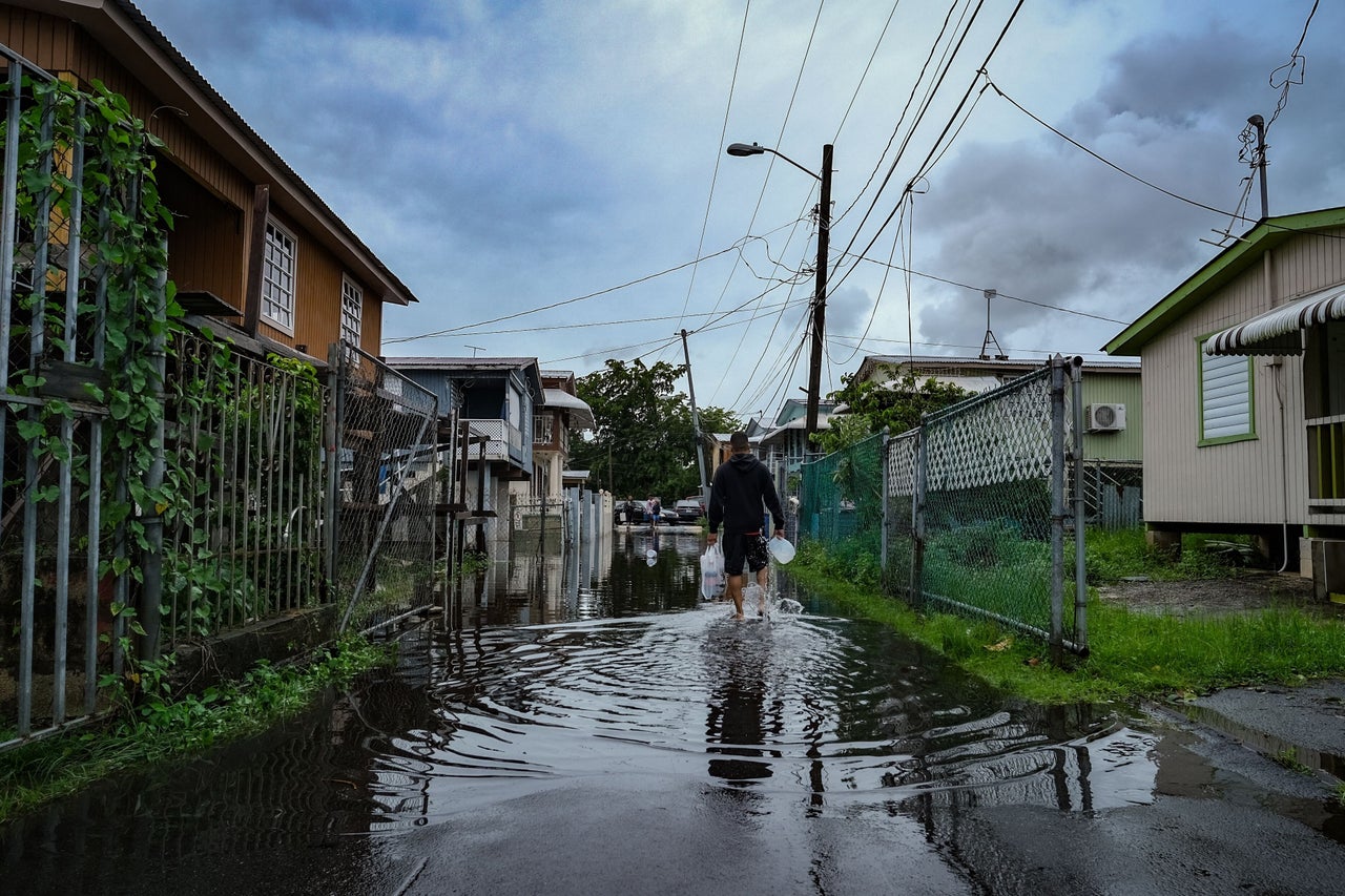 A man walks down a flooded street in the Juana Matos neighborhood of Catano, Puerto Rico, on Monday.