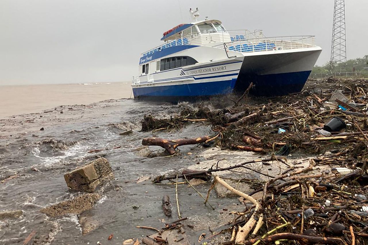 A boat lies washed up on shore Monday in Ponce, Puerto Rico.