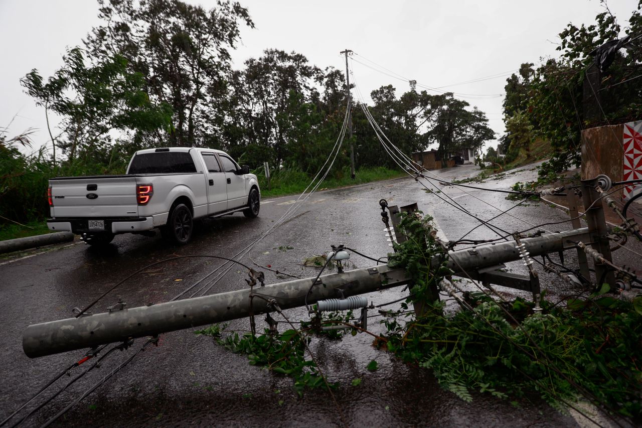 Power lines lie downed on a road in Cayey, Puerto Rico when the island was awakened Monday by a general power outage.