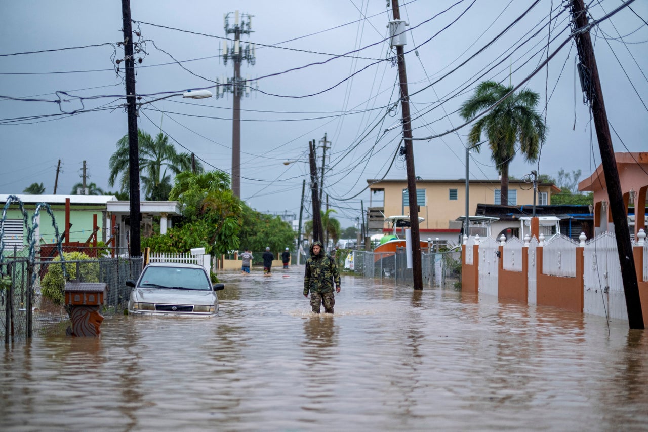 A member of the Puerto Rico National Guard wades through water Monday in search of people to be rescued from flooded streets in the aftermath of the hurricane in Salinas, Puerto Rico.