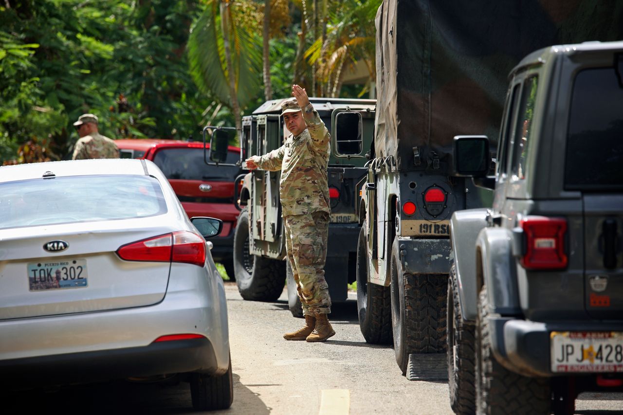 The National Guard is directing traffic on a Hurricane Fiona-hit road in Cayey, Puerto Rico, on Tuesday.