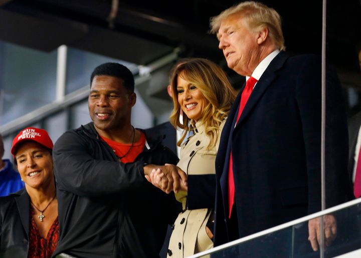 Herschel Walker interacts with former President Donald Trump prior to Game 4 of the World Series between the Houston Astros and the Atlanta Braves on Oct. 30, 2021, in Atlanta, Georgia.