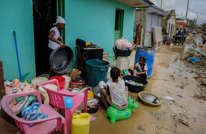 Neighbors work to recover their belongings from the flooding caused by Hurricane Fiona in the Los Sotos neighborhood of Higüey, Dominican Republic, on Sept. 20, 2022.