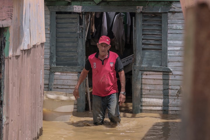 Nacácio Gil walks through stagnant water left by the swollen Deuai River after Hurricane Fiona passes by in the Los Sotos neighborhood of Higuay, Dominican Republic on September 20, 2022.