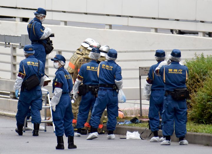 Police and firefighters inspect the scene where a man is reported to set himself on fire, near the Prime Minister's Office in Tokyo, on Sept. 21, 2022. 