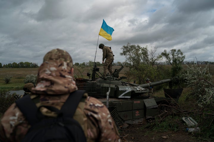A Ukrainian National Guard soldier stands on a destroyed Russian tank in the Kharkiv region of Ukraine on September 19, 2022.