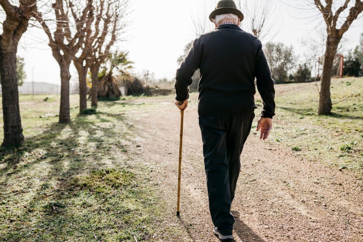 Hombre mayor caminando por el campo.