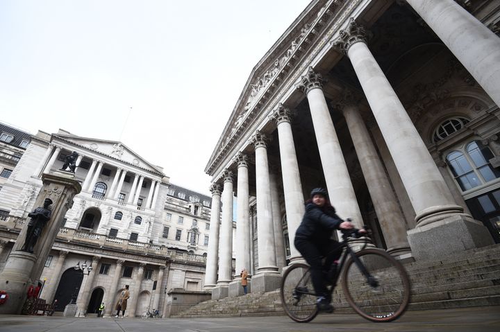 A woman cycling past the Bank of England.