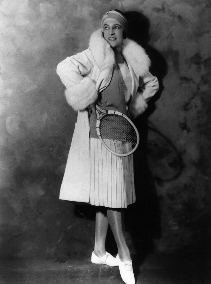 circa 1925: French tennis player Suzanne Lenglen modelling a new outfit, a below knee length pleated skirt and coat. (Photo by General Photographic Agency/Getty Images)