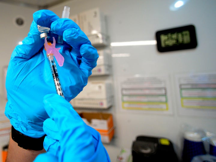 Ryan Dutton, an EMT from Rescue Inc., prepares shots of the Pfizer booster of the COVID-19 vaccine during a vaccine clinic held by Rescue Inc. at Leland & Gray Middle and High School, in Townshend, Vt., on Sept. 20, 2022.