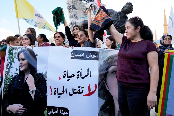 Kurdish activists in Beiruit hold headscarfs and a portrait of Iranian woman Mahsa Amini, with a sign reading: 'The woman is life, don't kill the life,' during against her death.