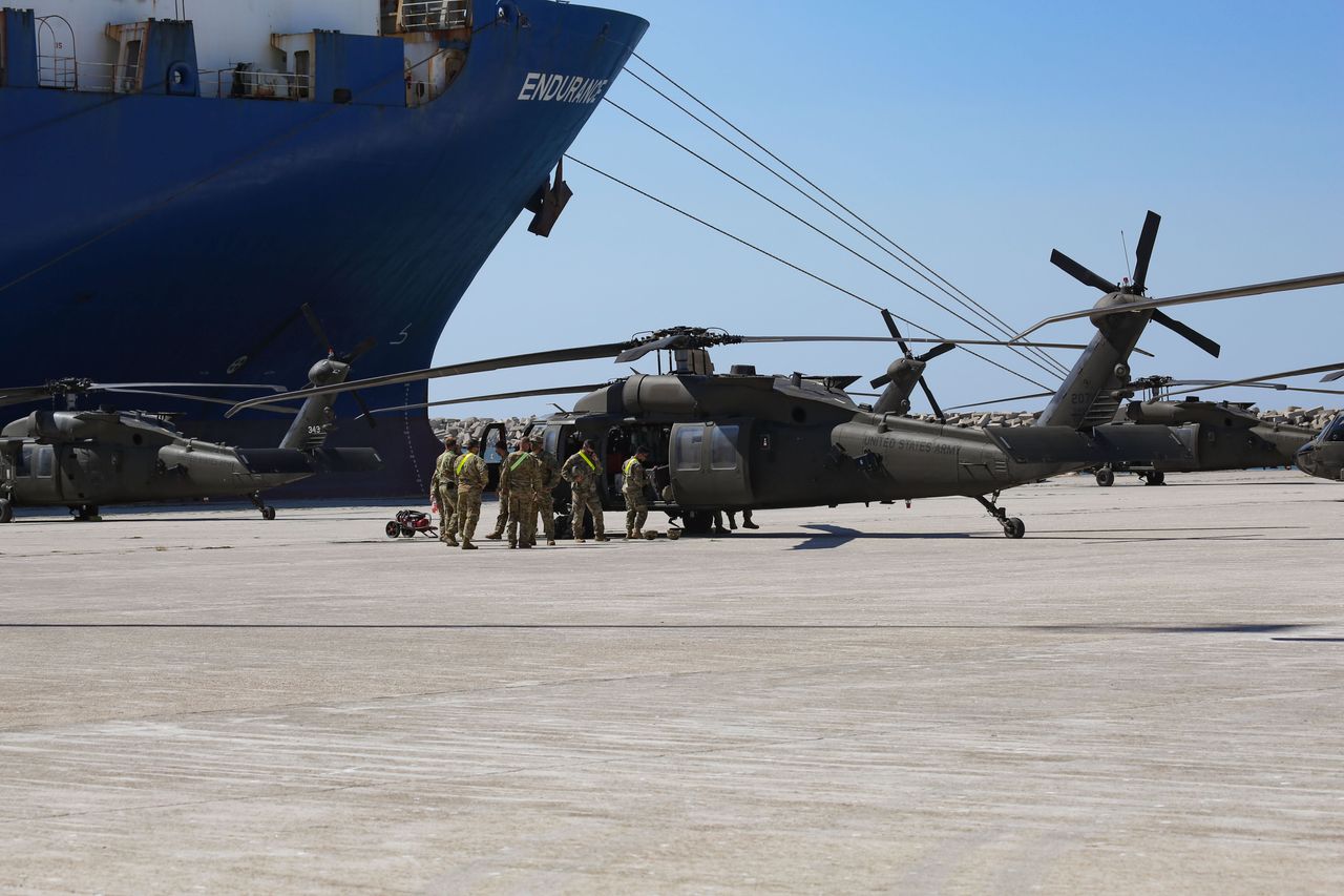 Τα στρατεύματα του Στρατού των Ηνωμένων Πολιτειών της Αμερικής συγκεντρώνουν και επισκευάζουν τα ελικόπτερα τους μετά την εκφόρτωσή τους από το πλοίο ARC στο λιμάνι της Αλεξανδρούπολης. Στρατεύματα της 101ης Αερομεταφερόμενης Μάχης Αεροπορίας με στολή σε υπηρεσία που εργάζονται στα ελικόπτερα και φορούν μάσκες προσώπου ως προληπτικά μέτρα ασφαλείας κατά της εξάπλωσης της πανδημίας του κορωνοϊού Covid-19. Η 101 Ταξιαρχία CAB του στρατού των ΗΠΑ φτάνει στο λιμάνι της Αλεξανδρούπολης στην Ελλάδα για να αναπτύξει στρατιώτες, ανθρώπινο δυναμικό, στρατεύματα, οχήματα και ελικόπτερα για τη στρατιωτική άσκηση του ΝΑΤΟ Atlantic Resolve 2020. Στις 23 Ιουλίου 2020 στην Αλεξανδρούπολη, Ελλάδα. (Photo by Nicolas Economou/NurPhoto via Getty Images)