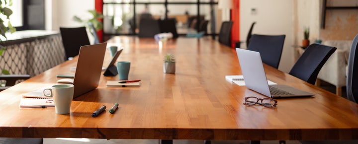 Nicely arranged and neatly organized business office with laptops and other office supplies on the table, no people