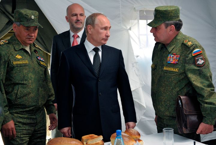 Ο Ρώσος Πρόεδρος Βλαντιμίρ Πούτιν, ακούει τον αναπληρωτή υπουργό Άμυνας Ντμίτρι Μπουλγκάκοφ, δεξιά, καθώς ο Υπουργός Άμυνας Σεργκέι Σόιγκου, αριστερά, και ο Κυβερνήτης της περιοχής της Βαϊκάλης Κονσταντίν Ιλκόφσκι, στο βάθος, παρακολουθούν στρατιωτικές ασκήσεις κοντά στη λίμνη Βαϊκάλη.