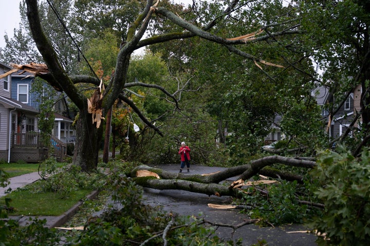 Georgina Scott surveys the damage on her street in Halifax as post tropical storm Fiona continues to batter the area on Saturday, Sept. 24, 2022. Strong rains and winds lashed the Atlantic Canada region as Fiona closed in early Saturday as a big, powerful post-tropical cyclone, and Canadian forecasters warned it could be one of the most severe storms in the country's history. (Darren Calabrese /The Canadian Press via AP)