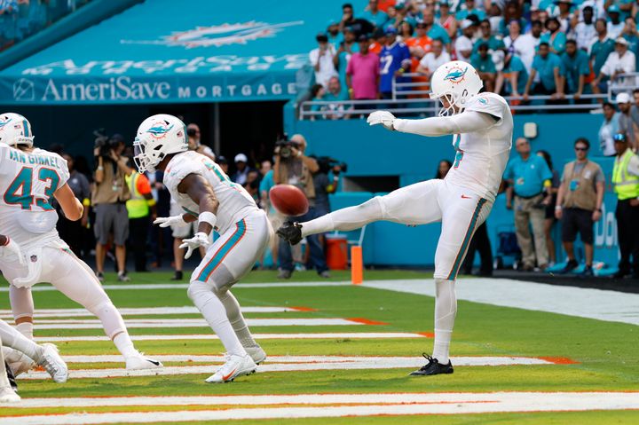 Miami Dolphins punter Thomas Morstead (4) punts the ball off the backside of Miami Dolphins wide receiver Trent Sherfield (14) for a safety during the game between the Buffalo Bills and the Miami Dolphins on Sunday at Hard Rock Stadium in Miami Gardens, Florida.