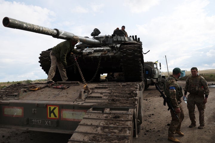 Un tanque ruso T-72 es cargado en un camión por soldados ucranianos en las afueras de la ciudad de Izyum.