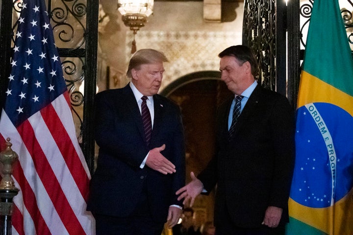 U.S. President Donald Trump shakes hands before a dinner with Bolsonaro at Mar-a-Lago, March 7, 2020, in Palm Beach, Florida.