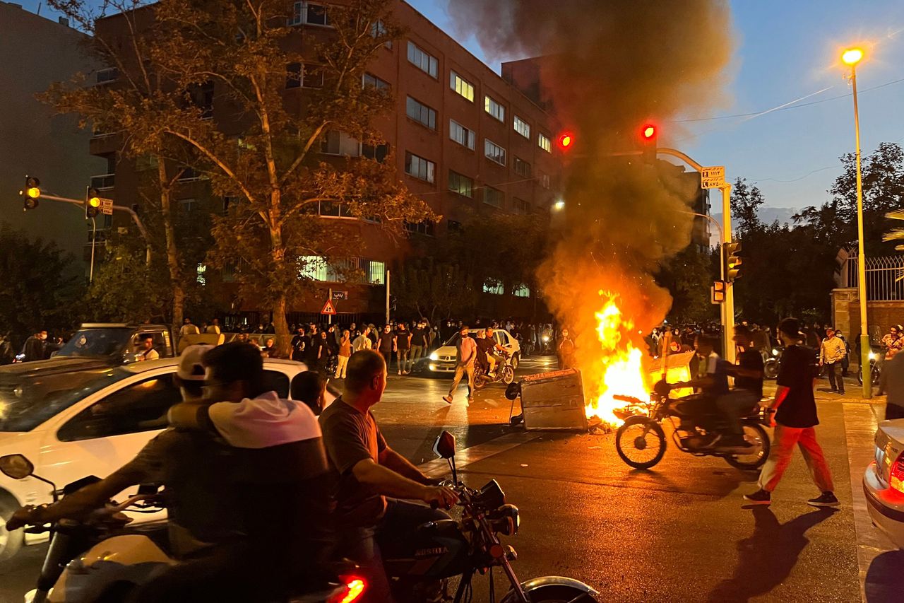A picture obtained by AFP outside Iran shows demonstrators gathering around a burning barricade during a protest for Mahsa Amini, who died after being arrested by the Islamic republic's morality police, in Tehran on Sept. 19.