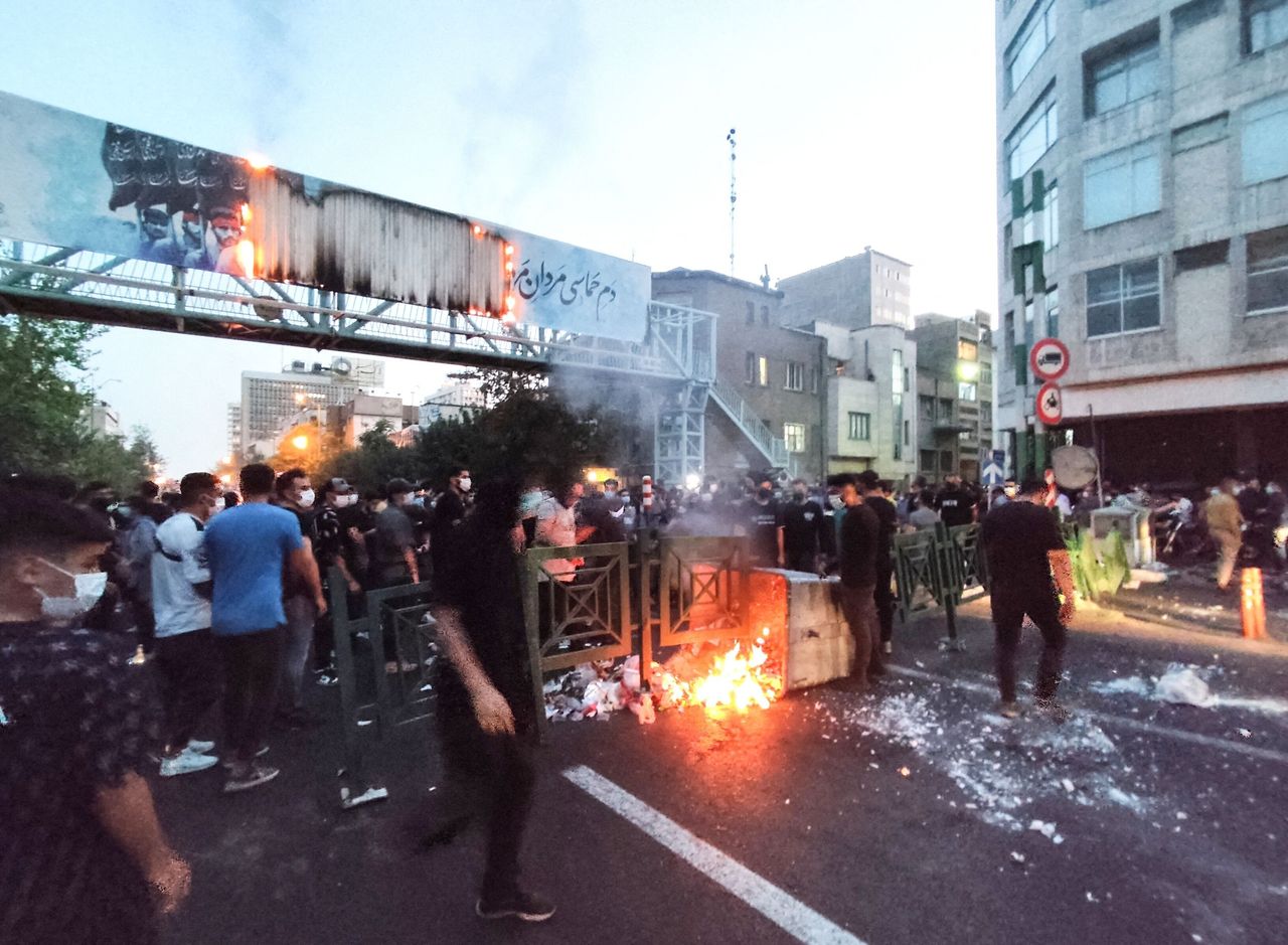 A picture obtained by AFP outside Iran on Sept. 21 shows Iranian demonstrators burning a rubbish bin in the capital Tehran during a protest for Mahsa Amini, days after she died in police custody. 