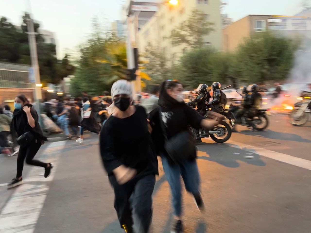  Women run away from anti-riot police during a protest in Tehran, September 19