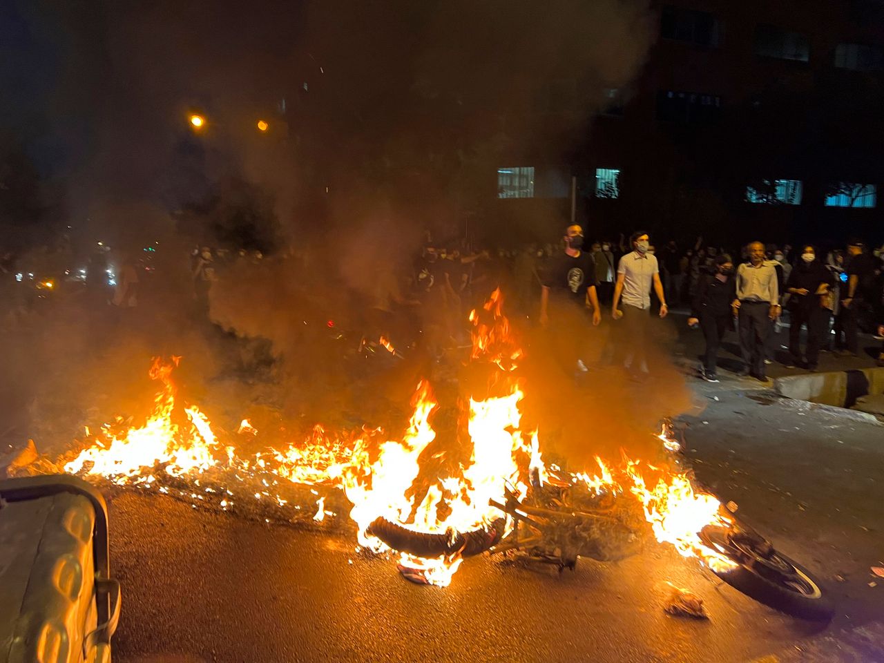 In this Monday, Sept. 19, photo taken by an individual not employed by The Associated Press and obtained by the AP outside Iran, a police motorcycle burns during a protest over the death of a young woman who had been detained for violating the country's conservative dress code, in downtown Tehran.