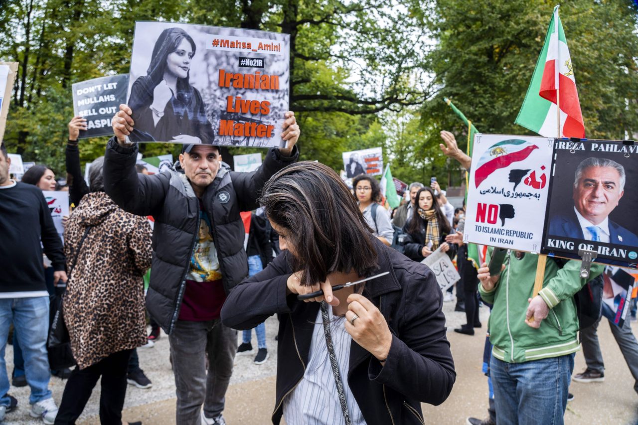 A protester cuts her hair during a rally against Iranian regime outside the House of Representatives in The Hague on Sept. 23, following the death of an Iranian woman after her arrest by the country's morality police in Tehran. 