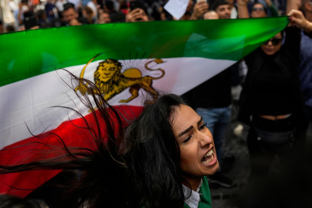 A woman shouts slogans next to an Iranian flag during a protest against the death of Iranian Mahsa Amini, outside Iran's general consulate in Istanbul, Wednesday, Sept. 21.