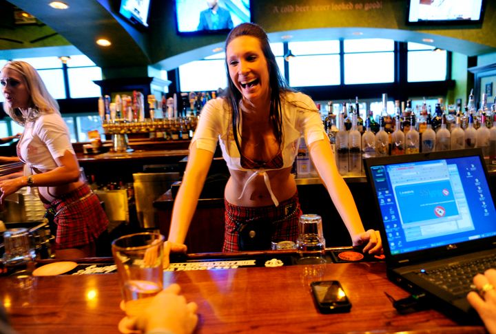 A bartender at The Tilted Kilt in Denver, Colorado, dons her tartan uniform.