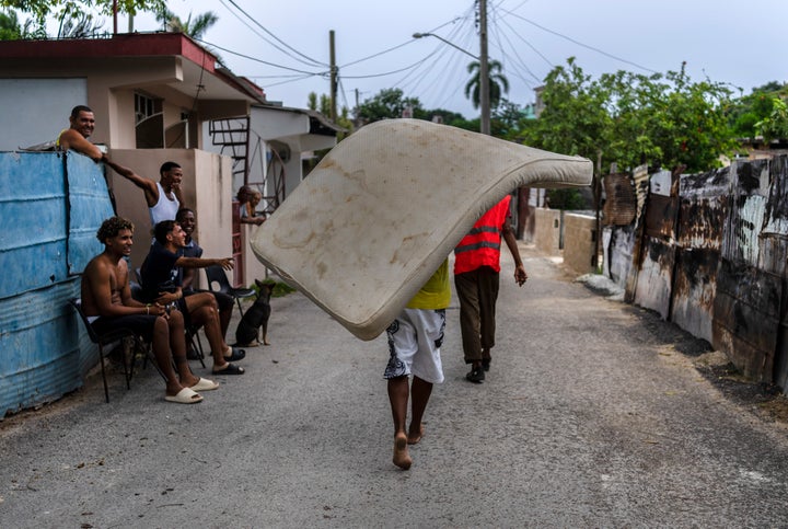 Residents of the El Fanguito neighborhood carry a mattress to a safe place in preparation for the arrival of Hurricane Ian in Havana, Cuba, on Monday.