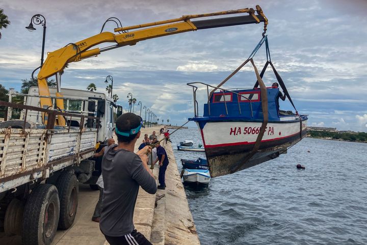 Εργαζόμενοι αφαιρούν μια βάρκα από το νερό στον κόλπο της Αβάνας, Κούβα, Δευτέρα, 26 Σεπτεμβρίου 2022. Ο τυφώνας γινόταν ισχυρότερος καθώς πλησίαζε στο δυτικό άκρο της Κούβας σε μια διαδρομή για να χτυπήσει τη δυτική ακτή της Φλόριντα ως μεγάλος τυφώνας ήδη από την Τετάρτη. (AP Photo/Milexsy Duran)