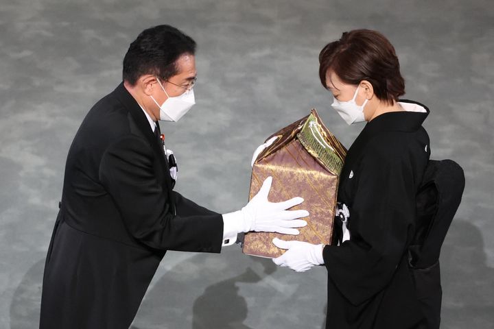Japan's Prime Minister Fumio Kishida, left, hands the urn of the ashes of former Japanese prime minister Shinzo Abe to his widow Akie Abe during his state funeral in the Nippon Budokan in Tokyo on Sept. 27, 2022. 