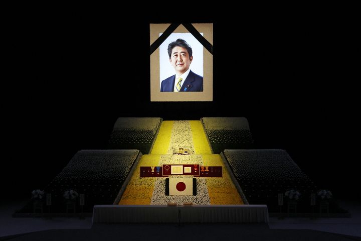 Ein Porträt von Japans ehemaligem Premierminister Shinzo Abe hängt während seines Staatsbegräbnisses im Nippon Budokan in Tokio am 27. September 2022 über der Bühne.