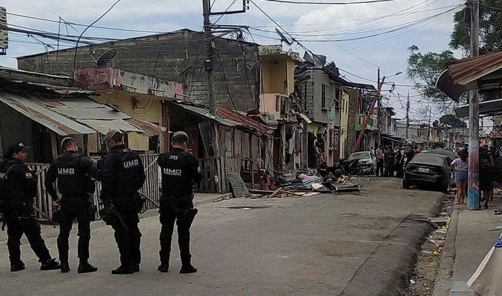 Μέλη των δυνάμεων ασφαλείας στέκονται κοντά στο σημείο μιας έκρηξης που άφησε τραυματίες και νεκρούς, καταστρέφοντας πολλά σπίτια και οχήματα, στο νότιο Γουαγιακίλ του Ισημερινού στις 14 Αυγούστου 2022. REUTERS/Vicente Gaibor del Pino
