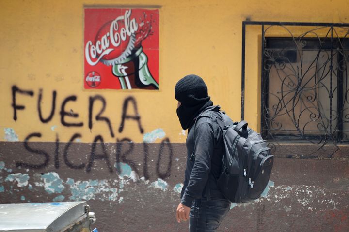Ένα μέλος της ομάδας αυτοάμυνας γνωστής ως «El Machete» περπατά δίπλα σε ένα γκράφιτι που γράφει «Sicario out» καθώς αναζητά μέλη συμμοριών ναρκωτικών κατά τη διάρκεια διαμαρτυρίας ενάντια στην αυξανόμενη βία στην περιοχή Pantelho, στην Πολιτεία Τσιάπας, Μεξικό 27 Ιουλίου 2021. Η φωτογραφία λήφθηκε στις 27 Ιουλίου 2021. REUTERS/Jacob Garcia