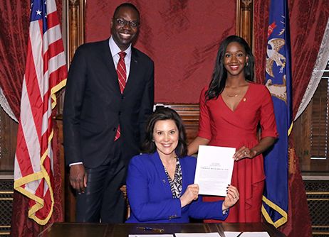 Michigan state Rep. Kyra Harris Bolden (right), here with Lt. Gov. Garlin Gilchrist II and Gov. Gretchen Whitmer, during Bolden's first bill signing. She studied politics and law after learning her great-grandfather had died in a lynching. Photo taken in Lansing, MI.