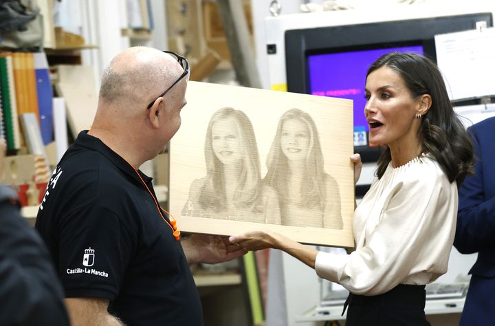 Letizia sostiene un cuadro con el rostro de sus dos hijas.