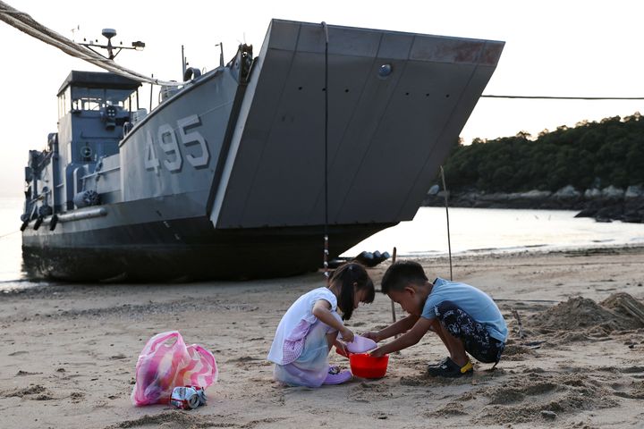 Children play with sand near a Taiwan Navy supply ship at a beach on Nangan island of Matsu archipelago in Taiwan August 16, 2022. REUTERS/Ann Wang